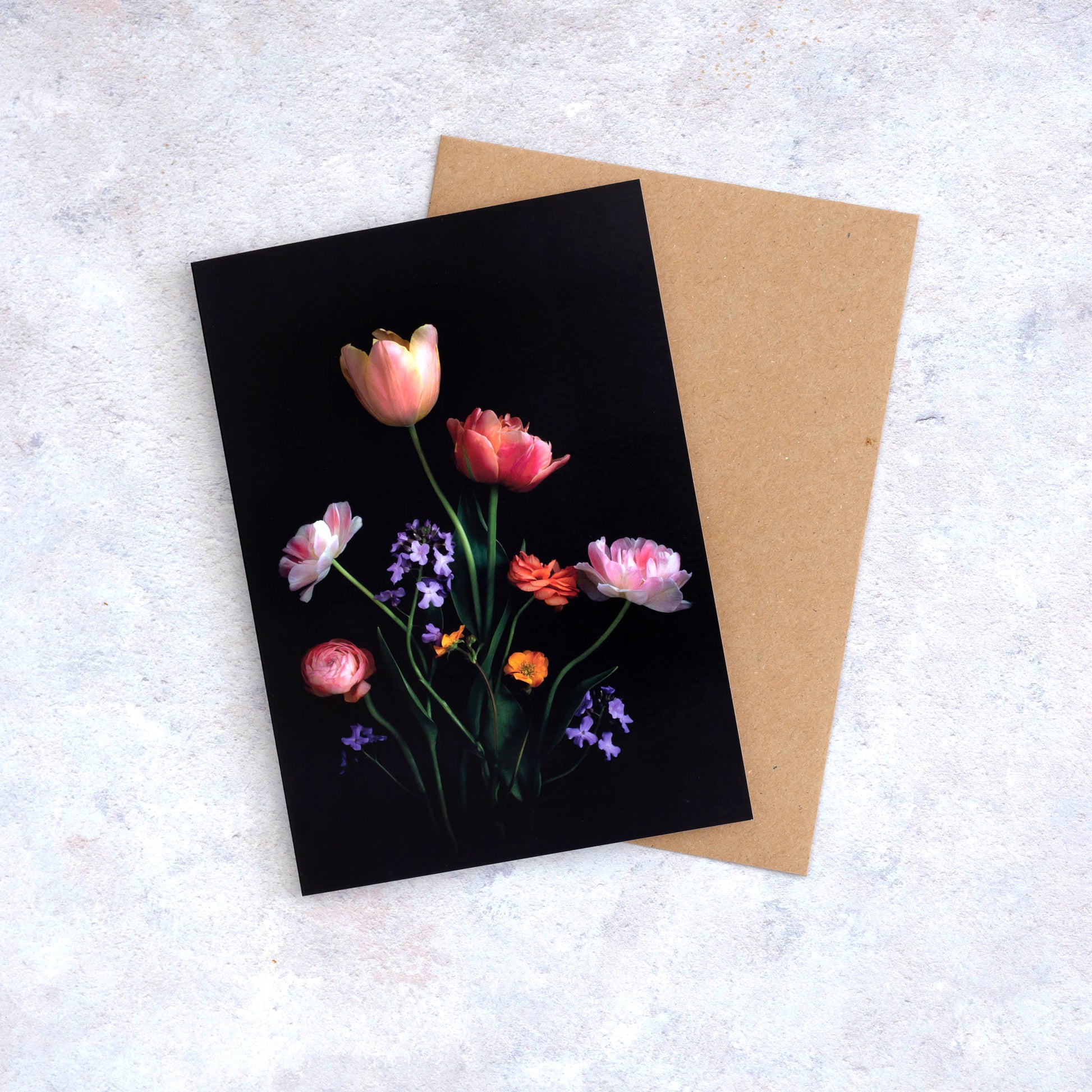 Botanical print greeting card with Tulips, Ranunculus, Geums and Honesty photographed on a black background.