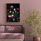 Portait format dark botanical print of Spring flowers photographed on a black background hung above a sofa on a pale warm pink wall.