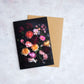 Botanical greeting card with mixed color Roses photographed on a dark grey background